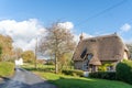 Traditional thatched cottage on a rural road through the village of Tarrant Monkton, Dorset, UK Royalty Free Stock Photo