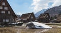 Traditional thatched roof houses with a rice paddy field nearby