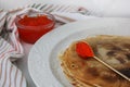 Russian traditional pancakes on a plate with a spoon, can of red caviar and a napkin in the background. close up Royalty Free Stock Photo