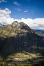 Traditional Tibetan village in rays of sun and mountain towering above