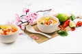 Traditional Tom Yum soup with blooming sakura branch on white stone table Royalty Free Stock Photo