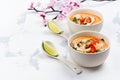 Traditional Tom Yum soup with blooming sakura branch on white stone table Royalty Free Stock Photo