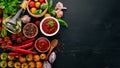 Traditional tomato ketchup sauce. Cherry tomatoes, spices, chili peppers, olive oil, parsley. Top view. Royalty Free Stock Photo