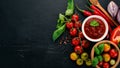 Traditional tomato ketchup sauce. Cherry tomatoes, spices, chili peppers, olive oil, parsley. Top view. Royalty Free Stock Photo