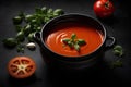 Traditional tomato soup with basil in a bowl on dark background. Commercial promotional food photo