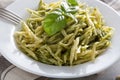 Traditional trofie pasta with pesto sauce on white plate