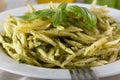 Traditional trofie pasta with pesto sauce on white plate