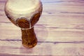 Traditional Tunisian drum made of clay and camel skin. Clay drum with leather membrane on a wooden table, copy space for text