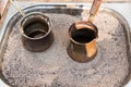 Traditional turkish coffee in cezve prepared on hot sand. Selective focus Royalty Free Stock Photo