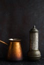 Traditional Turkish coffee and concept. Copper coffee pot. Cezve, vintage coffee grinder on a dark background Royalty Free Stock Photo