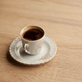 Traditional turkish coffee in patterned white cup on oak coffee table Royalty Free Stock Photo