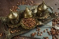 Traditional turkish coffee in vintage cup in metal service, anise, roasted beans on brown background 1 Royalty Free Stock Photo