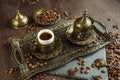 Traditional turkish coffee in vintage cup in metal service, anise, roasted beans on brown background 2 Royalty Free Stock Photo