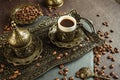 Traditional turkish coffee in vintage cup in metal service, anise, roasted beans on brown background 3 Royalty Free Stock Photo