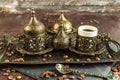 Traditional turkish coffee in vintage cup in metal service, anise, roasted beans on brown background 4 Royalty Free Stock Photo