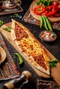 Traditional Turkish cuisine. Turkish pizza Pita with a different stuffing, meat, cheese, slices of veal. Turk Pidesi or Sucuk Pide