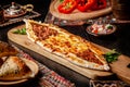 Traditional Turkish cuisine. Turkish pizza Pita with a different stuffing, meat, cheese, slices of veal. Turk Pidesi or Sucuk Pide