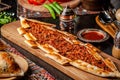 Traditional Turkish cuisine. Turkish pizza Pita with meat. Turk Pidesi or Sucuk Pide. Beautiful serving dishes in the restaurant