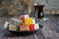 Traditional turkish delight and glass for tea bardak on dark wooden background Royalty Free Stock Photo