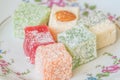 Traditional turkish delight on a plate on white wooden background. Assorted Oriental sweets Royalty Free Stock Photo