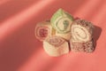 Traditional Turkish delight, rols shape, in coconut flakes , on pink background, sunlight, horizontal, no people,