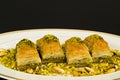 Traditional Turkish Pastry Dessert Pistachio Baklava on white oval plate with pistachio nuts