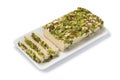 Traditional Turkish pistachio halva and slices ona plate on white background