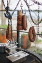 Traditional Turkish street food Kokoretsi also known as Kokorec and Sucuk meat sausage hanging on steel hook above barbecue