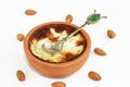 Traditional Turkish sweet supangle dish in a ceramic plate with a decor spoon on a white background