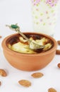 Traditional Turkish sweet supangle dish in a ceramic plate with a decor spoon on a white background