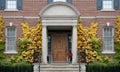 Traditional two story brick house, with elegant wood grain front door Royalty Free Stock Photo