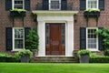 Traditional two story brick house with elegant wood grain front door Royalty Free Stock Photo