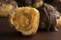 Traditional type of Brazilian profiterolis bakery candy called carolina in wood background with one open