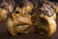 Traditional type of Brazilian profiterolis bakery candy called carolina in wood background with one open