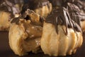 Traditional type of Brazilian profiterolis bakery candy called carolina in wood background with one open close