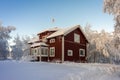 Traditional typical Scandinavian Swedish house or villa in the countryside in winter. Snowy village. Old wooden red house cottage Royalty Free Stock Photo