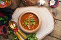 Traditional Ukrainian beet soup borscht in wooden bowl with garlic buns pampushka and dry cured pork belly on rustic wooden table