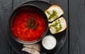 Traditional Ukrainian borscht. Bowl of red beetroot soup borscht with white cream and garlic pampushka. Beetroot soup on