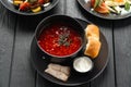 Traditional Ukrainian borscht. Bowl of red beetroot soup borscht with white cream and garlic pampushka. Beetroot soup on