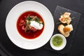 Traditional Ukrainian borscht soup with white bread and bacon on black background Flat lay Top view