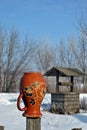 Traditional Ukrainian rural landscape with a wooden well and fence with hanging pitcher on it with Petrykivka folk painting