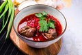 Traditional Ukrainian Russian Borscht with bacon, hot soup with beets, cabbage and carrots in a bowl on a wooden board. Served Royalty Free Stock Photo