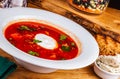 Traditional Ukrainian Russian borscht or beetroot red soup with sour cream in white plate Royalty Free Stock Photo