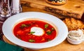 Traditional Ukrainian Russian borscht or beetroot red soup with sour cream in white plate Royalty Free Stock Photo
