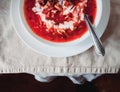 Traditional Ukrainian-Russian tomato borscht soup with sour cream in a white plate on the table. View from above Royalty Free Stock Photo