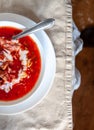 Traditional Ukrainian-Russian tomato borscht soup with sour cream in a white plate on the table. View from above Royalty Free Stock Photo