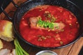 Traditional Ukrainian Russian vegetable borscht. Ukrainian beetroot soup in a bowl with meet, greenery and garlic bread Royalty Free Stock Photo