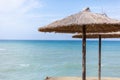 Traditional umbrella above the cliff. The wooden hut overlooking the open sea. Strong waves approaching the shoreline. Tropical tr Royalty Free Stock Photo