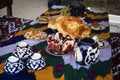 Traditional Uzbek bread on table with mugs and kettle. Cuisine of Central Asia. fruits grapes and pomegranate and sweets Royalty Free Stock Photo