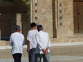 Traditional Uzbek men walking in front of a mosque to Samarkand in Uzbekistan.
